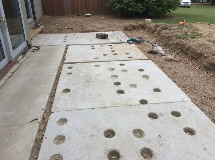Grid of small injection ports drilled across a sunken patio section
