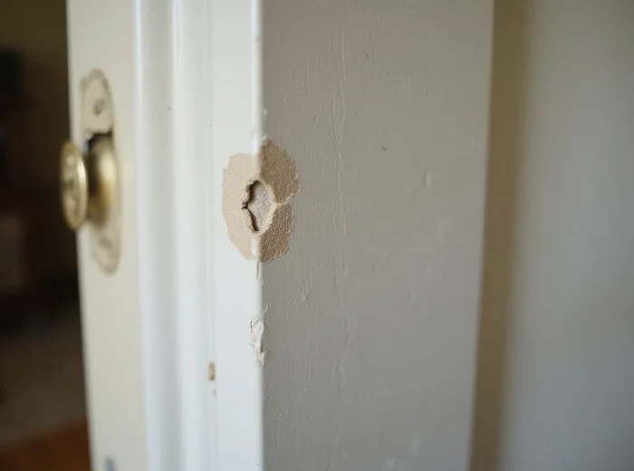 Interior door rubbing against its frame with a wear mark at the top corner